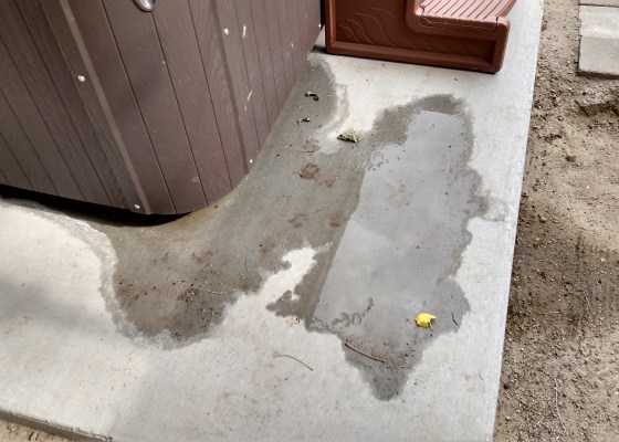 Hot Tub with water coming out on the ground from within the cabinet.