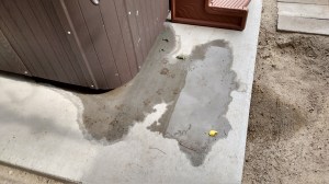 Hot Tub with water coming out on the ground from within the cabinet.