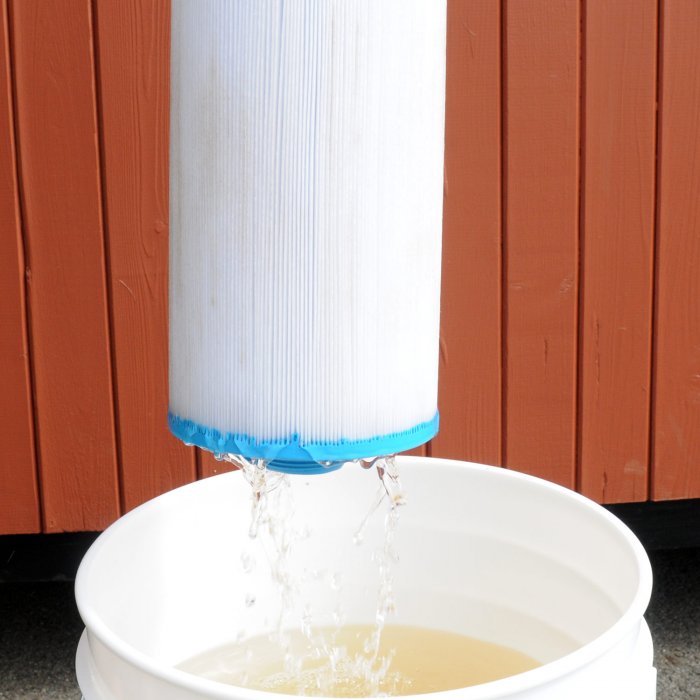 perfectly clean filter being withdrawn from bucket after being soaked with power soak solution