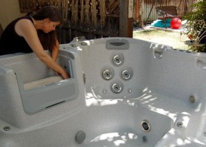 woman cleaning and installing filter in hot tub